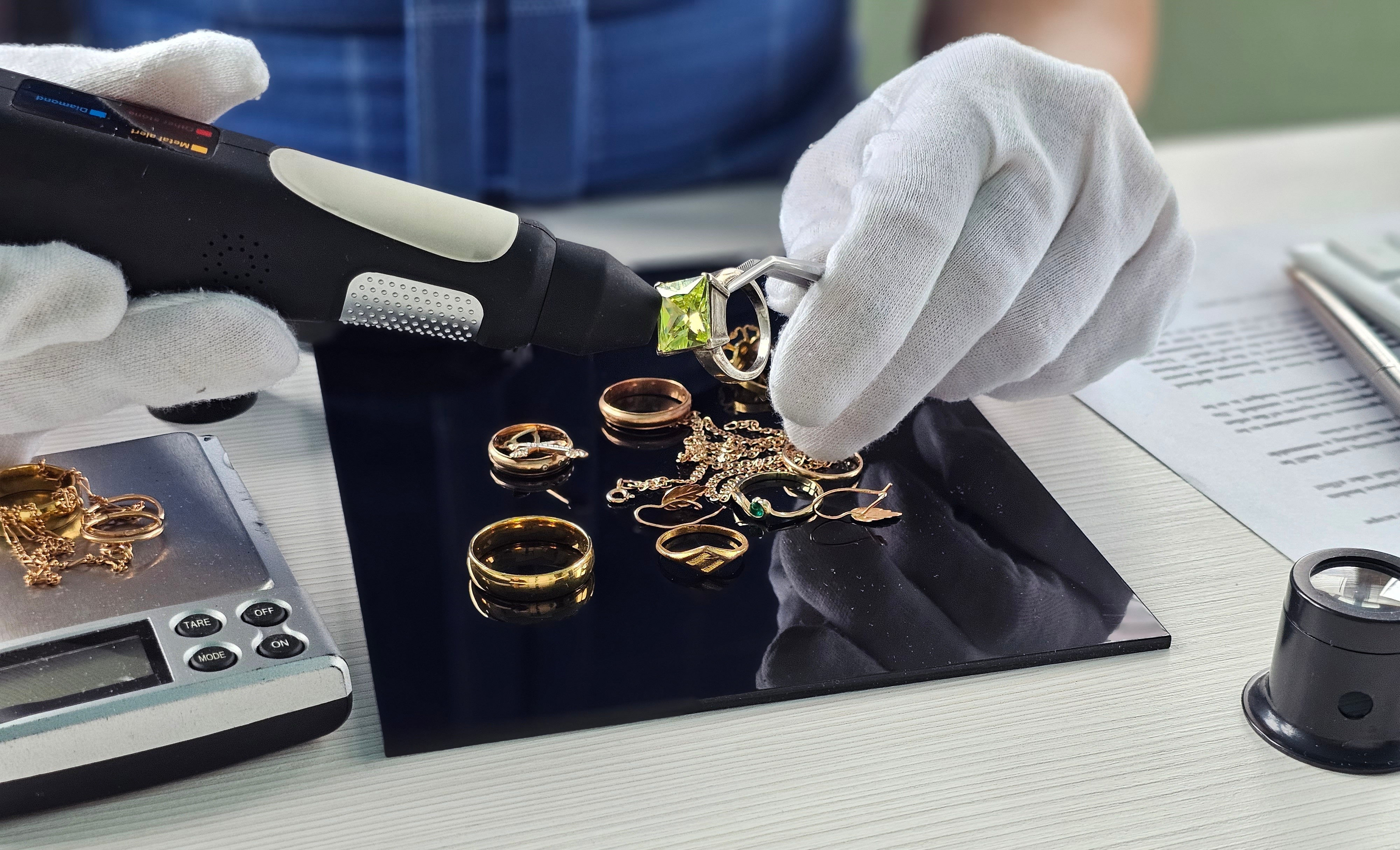 Expert valuation in progress — a Jewellery Roadshow buyer examines a gold watch under magnification